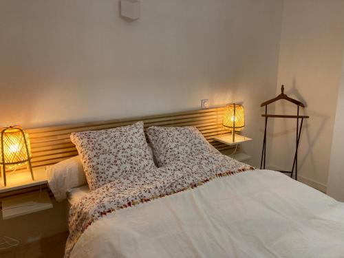 a bedroom with a white bed with two lamps at La Rolande in Aix-en-Provence