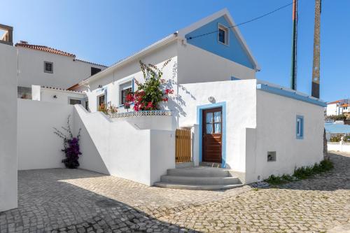 Casa blanca con escalera y puerta en Carvoeira Surf & Family Villa, en Carvoeira