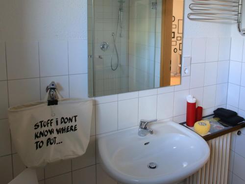 a bathroom sink with a sign on the wall at apartment-S Sonnenrain in Lörrach