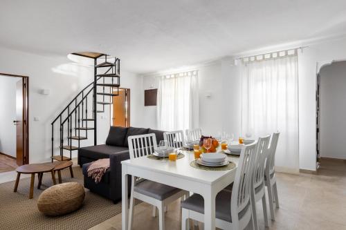 - un salon avec une table et des chaises blanches dans l'établissement Carvoeira Surf & Family Villa, à Carvoeira