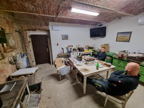 two people sitting at a table in a room at Cozy rustical house in the highland (entire place) in Kožlí