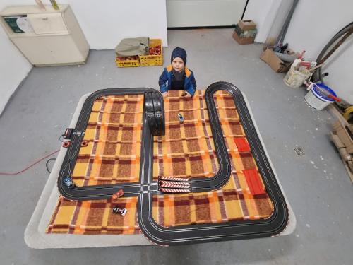 a young child is sitting on top of an empty suitcase at Cozy rustical house in the highland (entire place) in Kožlí