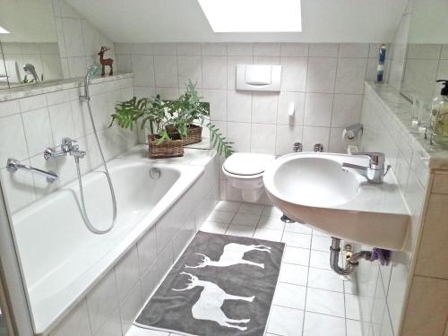 ein Badezimmer mit einer Badewanne, einem Waschbecken und einem WC in der Unterkunft Ferienwohnung Steger in Aschau im Chiemgau