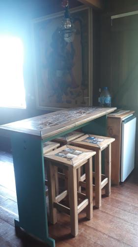 a kitchen with a counter with a table and stools at Solar da Lagoa in Florianópolis