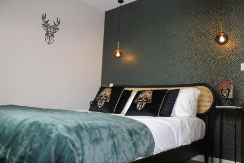 een slaapkamer met een bed met een groene muur bij Le gite des 3 mousquetaires in Amboise