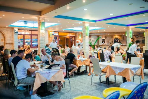a group of people sitting at tables in a restaurant at La caretta in Alikanas