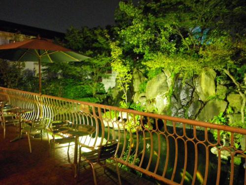 eine Gruppe von Stühlen und Tischen mit einem Schirm in der Unterkunft Hotel Seagull in Izumi-Sano