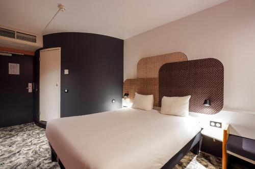 a bedroom with a large white bed in a room at B&B HOTEL Paris Nord 2 CDG Aéroport in Roissy-en-France