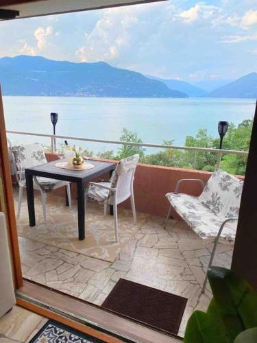 a balcony with a table and chairs and a view of the water at Ferienwohnung Studio Belvedere in Brezzo
