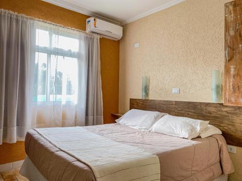 クアトロ・バーハスにあるPousada do Anhangavaのベッドルーム1室(大型ベッド1台、窓付)