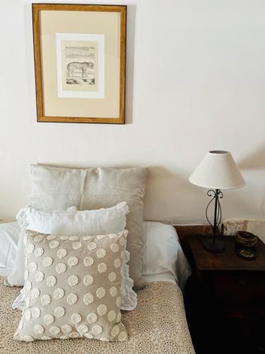 a bedroom with a bed with a pillow and a lamp at Le logis de Lasteyrie in La Rochebeaucourt-et-Argentine