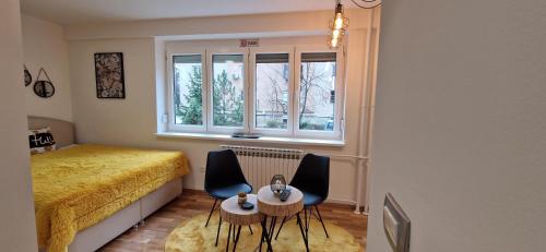 une chambre avec un lit, deux chaises et une table dans l'établissement Apartment GOLD STAR, à Sarajevo