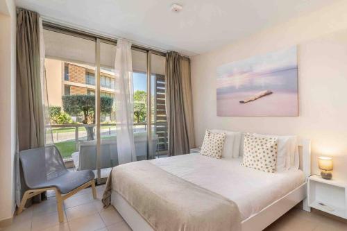 a bedroom with a bed and a large window at Salgados Beach House 2-Bedroom & 7 Pools in Guia