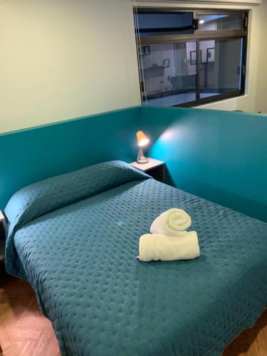 Una cama con una toalla blanca encima. en Buganvilias 22, en Ciudad de México