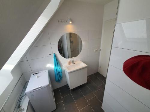 a white bathroom with a sink and a mirror at Kiel-Russee Familienwohnung, Lademöglichkeit, Co2 Frei in Kiel