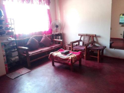 uma sala de estar com um sofá e duas cadeiras em Weng em Tacloban