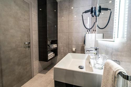 a bathroom with a white sink and a mirror at Calma Luxury Rooms in Split