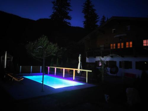una piscina por la noche con luces azules en Gästehaus Waldrast en Ramsau