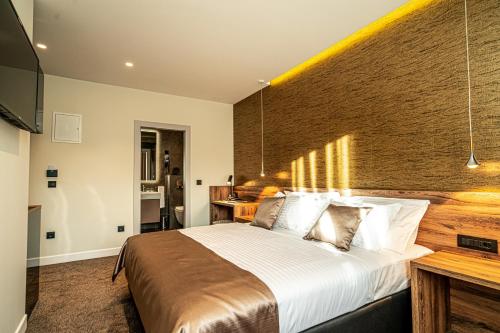 a bedroom with a large bed with a brick wall at Calma Luxury Rooms in Split