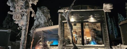 une fenêtre d'un bâtiment dans la neige la nuit dans l'établissement Levi Secret Igloo Revontuli, à Sirkka
