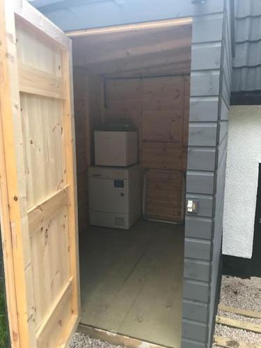 an outside view of a building with a door and a refrigerator at Riverside Hideaway in Kincraig