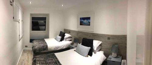 a hotel room with two beds in a room at Riverside Hideaway in Kincraig