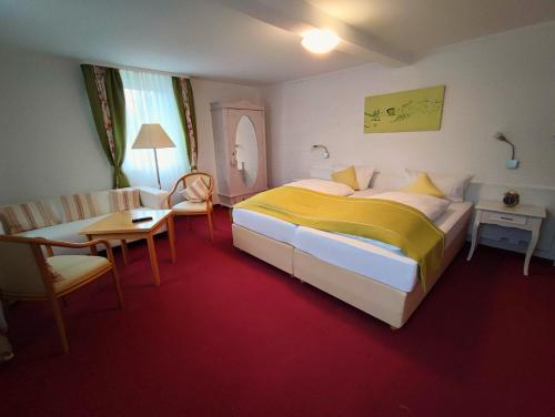 a hotel room with a bed and a table and chair at Room in Guest room - Pension Forelle - double room no01 in Forbach
