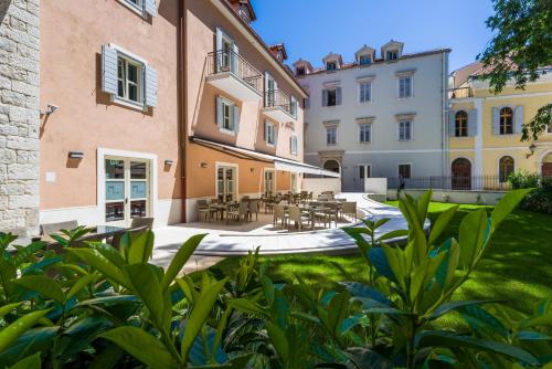 a courtyard with tables and chairs in a building at Calma Luxury Rooms in Split