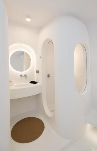 a white bathroom with a sink and a mirror at Villa Costa by Whitelist Mykonos in Ftelia