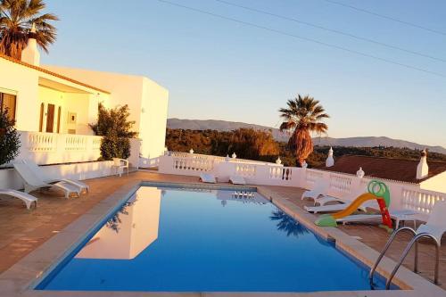 - une piscine avec des chaises et un toboggan dans une maison dans l'établissement Blue Skies Villas 1&2, à Mexilhoeira Grande