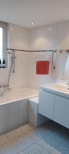 a white bathroom with a tub and a sink at House close to beach and city in Hoorn