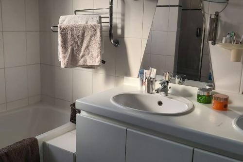 a white bathroom with a sink and a bath tub at House close to beach and the city of Hoorn in Hoorn