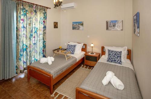 a bedroom with two beds and a window at Ruby's summer house with spacious garden and free parking in Gavrion