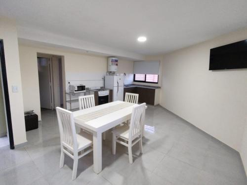 a kitchen with a white table and chairs in a room at Alpaquitay 1 in Mendoza