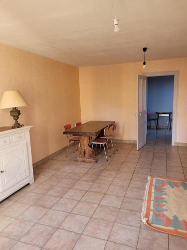 un salon avec une table et des chaises en bois dans l'établissement Petite Maison à Salbris, à Salbris