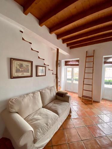 a living room with a couch and a staircase at Casa da Joana by Portus Alacer in Portalegre