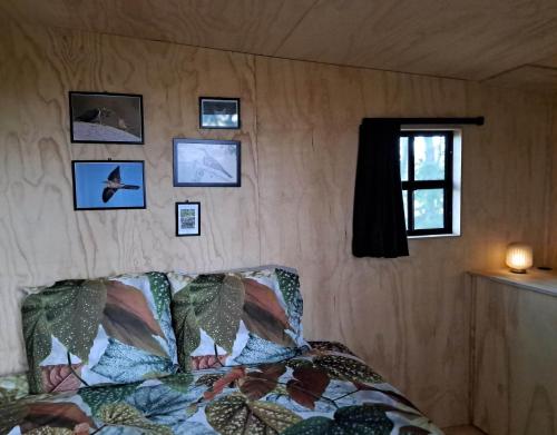 een slaapkamer met een bed en foto's aan de muur bij De Koekoek in Brugge