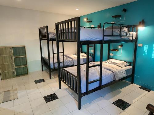 3 literas en una habitación con paredes azules en Blue Moon House - A budget hostel for easy travellers, en Chiang Mai