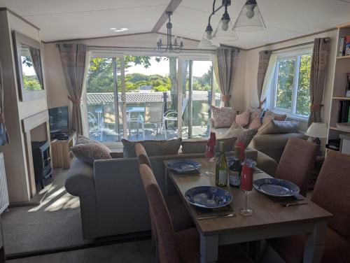 a living room with a table and a couch at STUNNING LUXURY Caravan on edge of New Forest on SHOREFIELD Country Park ENTERTAINMENT AND LEISURE PASSES INCLUDED in Milford on Sea