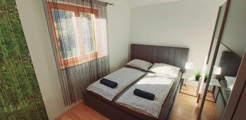 Un dormitorio pequeño con una cama y una ventana. en Mediterran Apartman, en Zalakaros