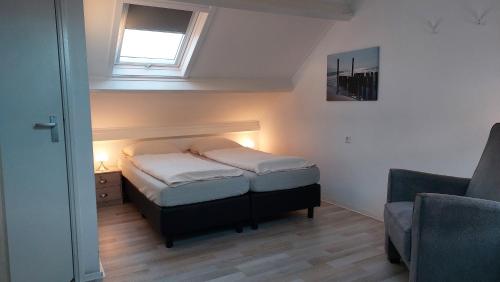 ein kleines Schlafzimmer mit einem Bett und einem Fenster in der Unterkunft Appartement vlakbij strand en centrum in Zoutelande