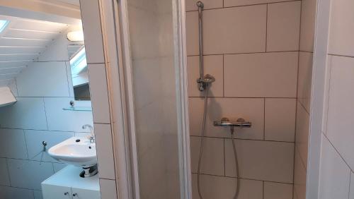 ein Bad mit einer Dusche und einem Waschbecken in der Unterkunft Appartement vlakbij strand en centrum in Zoutelande