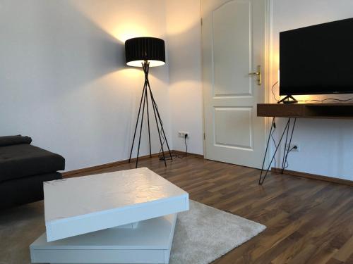 a living room with a tv and a couch and a table at APT im Herzen von Mainz in Mainz