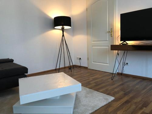 sala de estar con TV, sofá y mesa en APT im Herzen von Mainz, en Mainz