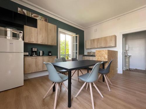 une cuisine avec une table et des chaises dans une pièce dans l'établissement Le Logis de la Place, à Thouars