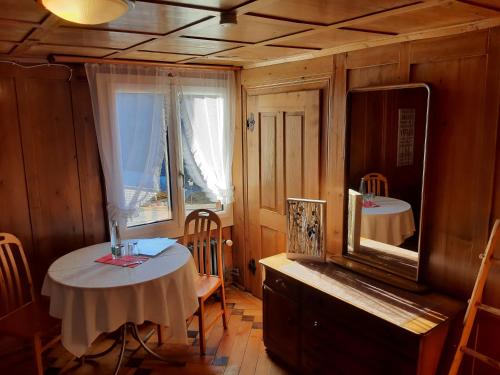 ein Esszimmer mit einem Tisch und einem Spiegel in der Unterkunft Gasthaus Schwand in Engelberg