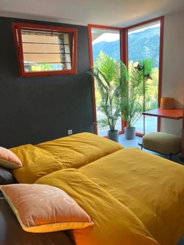 - une chambre avec un lit jaune, une table et des fenêtres dans l'établissement DELUXE VILLA ASTERISK at MONT VENTOUX, à Mollans-sur-Ouvèze