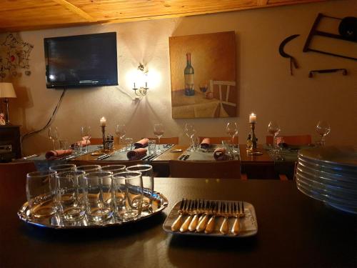 una mesa con platos y vasos encima en Le Heron Pourpre B&B gastronomique, en Cronat