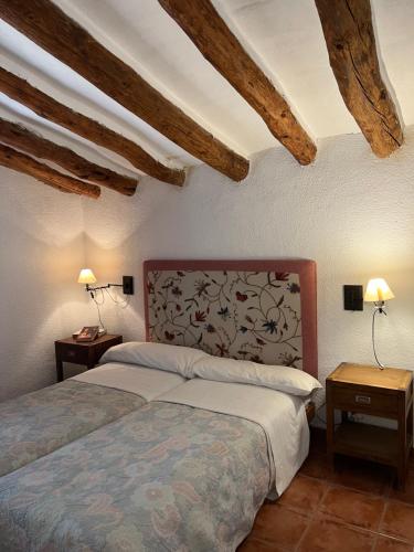 a bedroom with two beds and two lamps on tables at Cortijo EL COSIO in Benamaurel