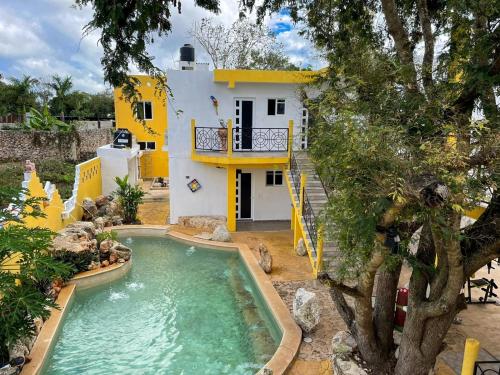 una casa con piscina frente a ella en Buenosdías Izamal, en Izamal